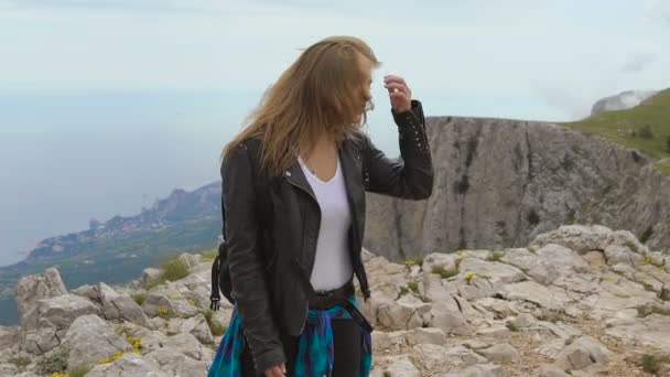 Νεαρή γυναίκα που στέκεται πάνω σε βράχο. — Αρχείο Βίντεο