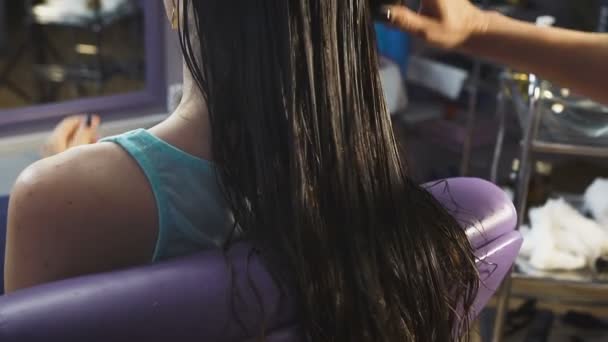 Όμορφη νεαρή κοπέλα σε ένα σαλόνι ομορφιάς για τα μαλλιά παίρνει υγείας διαδικασία. — Αρχείο Βίντεο
