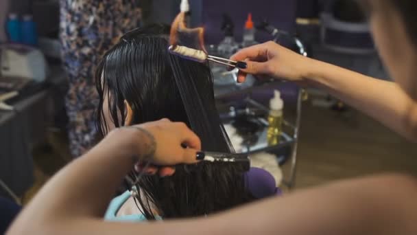 Estúdio de beleza, para morenas com cabelo longo fazendo processo de corte de cabelo fogo . — Vídeo de Stock