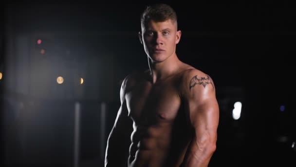 Bodybuilder sur la forme supérieure. Belle jeune athlète posant pour une séance photo — Video