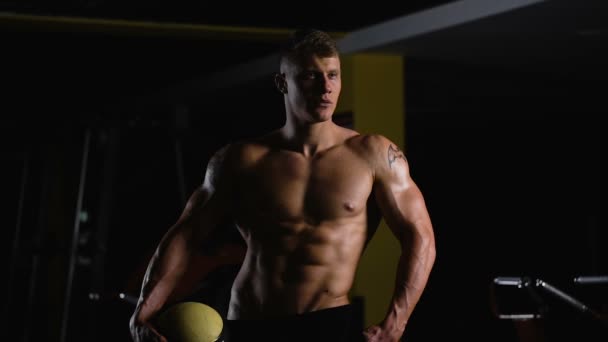 Bodybuilder på toppform. Vacker ung idrottsman poserar för ett fotosession — Stockvideo