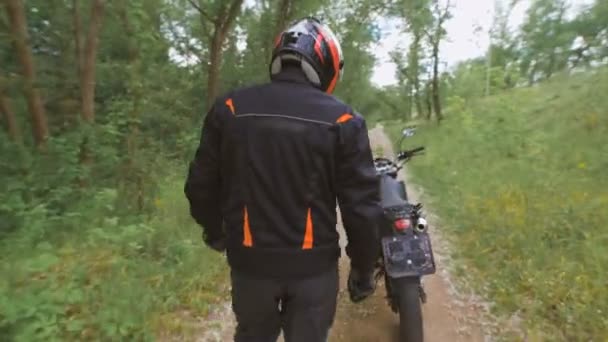 The countryside. Motorcyclist goes into full gear to his motorcycle. — Stock Video