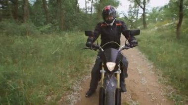 Kırsal. ağaçlar ve çalılar arasında toprak yol boyunca bisiklet sürmek.