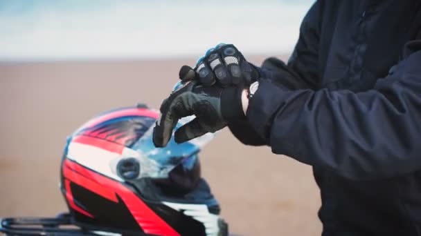 Motorcyclist removes his gloves. — Stock Video