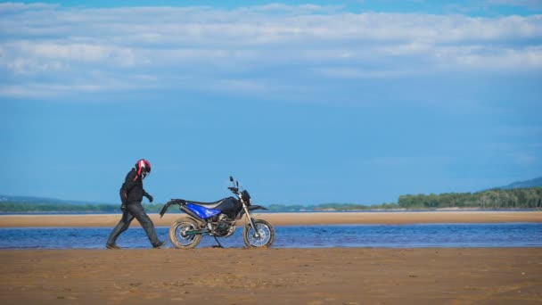 Hermosa orilla del río. Moto motociclista monta su bicicleta para que comenzaría a moverse — Vídeos de Stock