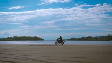 Özgürlük ve Moto estetik duygusu. Motosikletçi kum plajındaki Onun Bisiklet sürme.