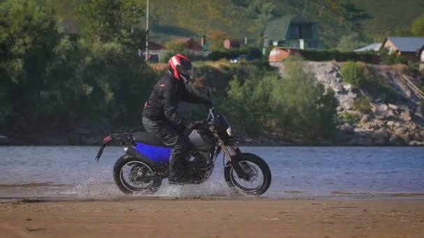 Extrem körning en motorcykel. En skicklig cyklist ridning på kanten av vatten — Stockvideo