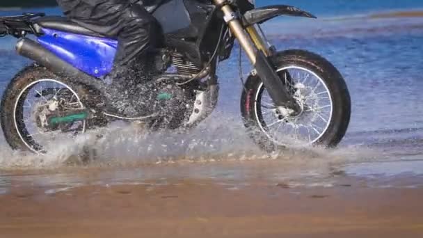Extremes Motorradfahren. ein erfahrener Biker, der am Rande des Wassers fährt — Stockvideo