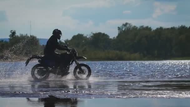 Romantyczny wyjazd na motocyklu. Wykwalifikowanych rowerzysta jeździ na krawędzi wody, — Wideo stockowe