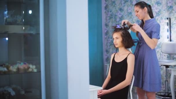 Schwester macht Locken für seine Freundin. sie reden und tratschen. — Stockvideo