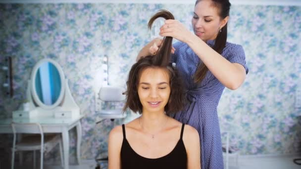 I professionell salong hårklippning gör mästaren hårstyling för en ung flicka. — Stockvideo