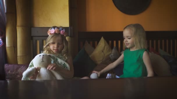 Duas meninas bonitos estão jogando em um café — Vídeo de Stock