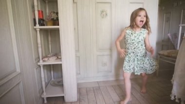 Kapalı bir güneşli beyaz Oda evde ya da anaokulu dans eğleniyor elbiseli mutlu sarışın kız