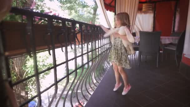 Happy blonde girl in the dress having fun dancing at a bright balcony — Stock Video