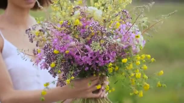 Zomer bloeiende veld en een mooi meisje in een witte sundress. — Stockvideo