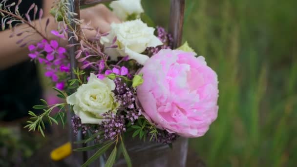 Smal tjej i svart klänning fungerar av blommor vid solnedgången — Stockvideo