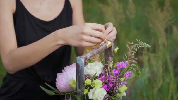 Schlankes Mädchen im schwarzen Kleid arbeitet mit Blumen bei Sonnenuntergang — Stockvideo