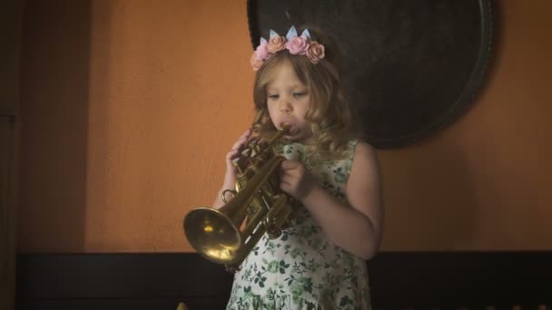 A little cute girl is playing saxophone in a cozy cafe — Stock Video