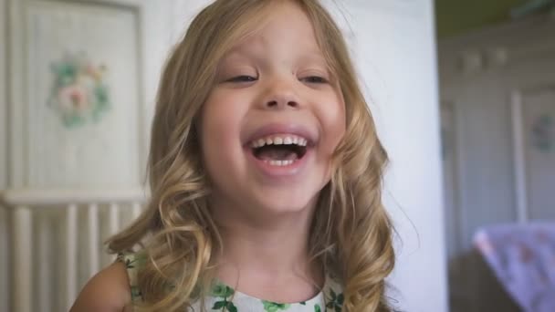 A beautiful little girl is smiling in the bright room — Stock Video