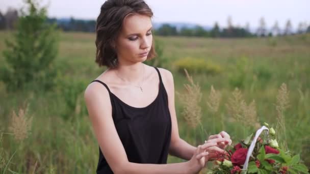 Attraktive Brünette macht ein Blumengesteck aus Rosen. — Stockvideo
