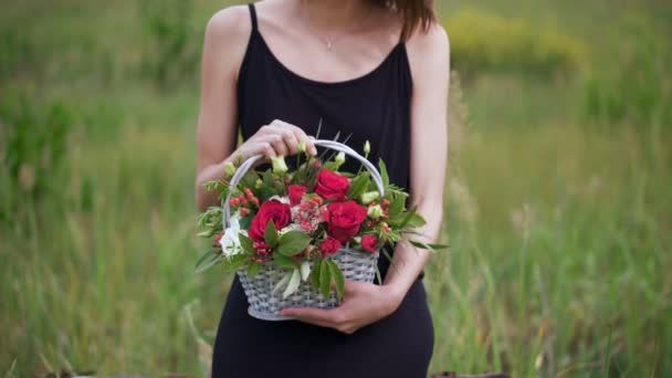 Närbild profil porträtt av en vacker och ung kvinna njuter och luktar en bukett blommor — Stockvideo