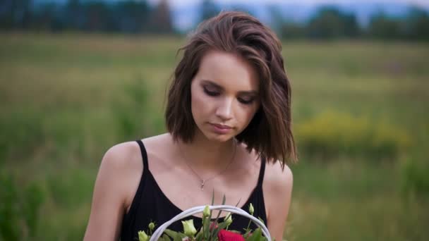 Close up retrato perfil de uma mulher bonita e jovem apreciando e cheirando um buquê de flores — Vídeo de Stock