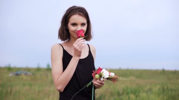 Mooi slank meisje creëert een krans van bloemen. — Stockvideo