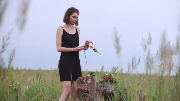 Beautiful slender girl creates a wreath of flowers. — Stock Video