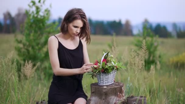 Close up retrato perfil de uma mulher bonita e jovem apreciando e cheirando um buquê de flores — Vídeo de Stock