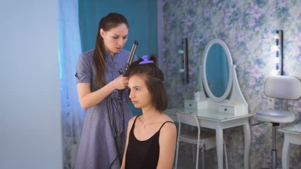 Um estilista fazendo cabelo para uma noiva bonita antes do casamento em uma manhã — Vídeo de Stock