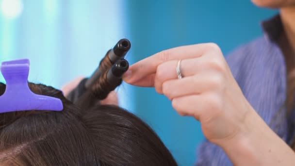 Een Hair Stylist maken krullend haar aan een bruid. — Stockvideo