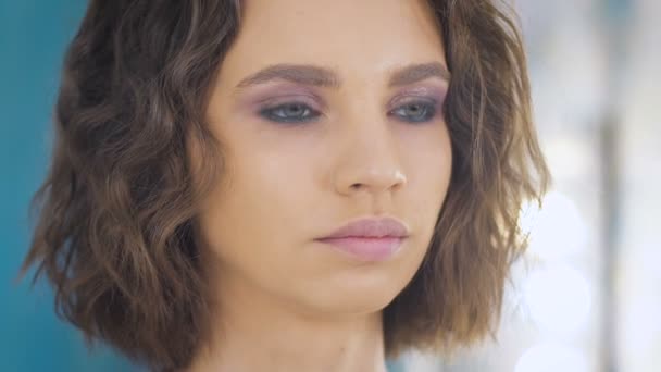 Professionell makeup artist tillämpa göra upp på en vacker ung ansikte för en fotografering — Stockvideo