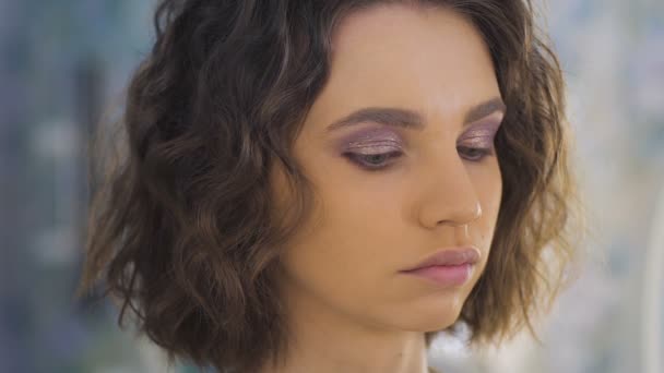 Επαγγελματίας καλλιτέχνης μακιγιάζ εφαρμογή make up σε ένα όμορφο νεαρό πρόσωπο για μια φωτογράφιση — Αρχείο Βίντεο