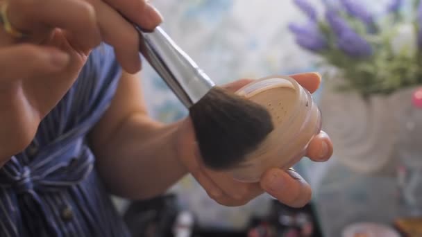 Een make-up artiest met behulp van een borstel met het poeder. — Stockvideo