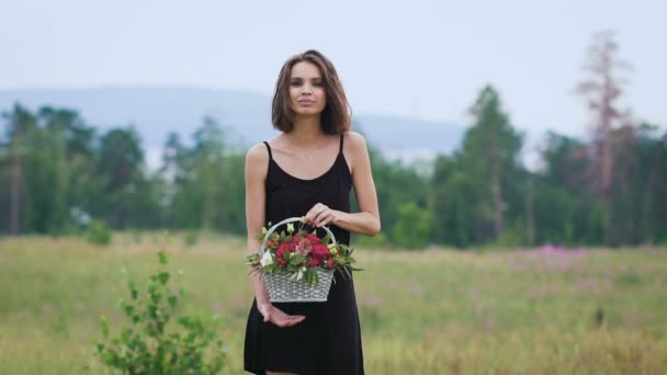 Mooi meisje in de zwarte korte jurk op het groene veld. — Stockvideo