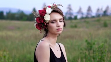 Yeşil alanda kafasına çelenk ile siyah kısa elbise güzel kız.