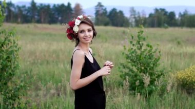 Yeşil alanda kafasına çelenk ile siyah kısa elbise güzel kız.
