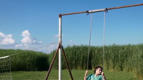 Beautiful young woman swinging outdoors — Stock Video