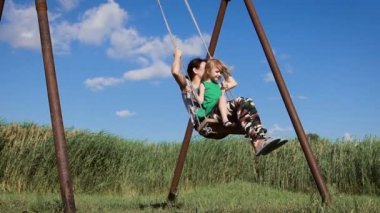 Sevimli küçük bir kız açık havada sallanan olan güzel kadın