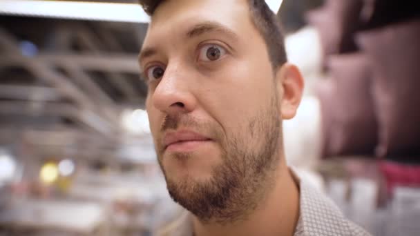 Jeune homme regardant une caméra dans le magasin — Video