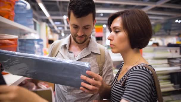 Hermosa pareja joven eligiendo cajas y contenedores en la tienda — Vídeos de Stock