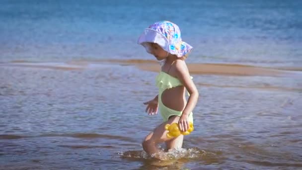 Linda niña rubia divirtiéndose junto a un lago — Vídeos de Stock