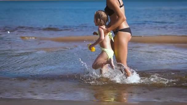 Madre jugando girando alrededor de su hija niña en el lago — Vídeo de stock