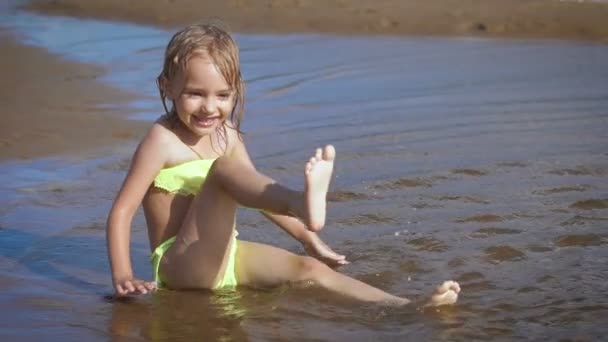 Cute little blonde girl having fun by a lake — Stock Video