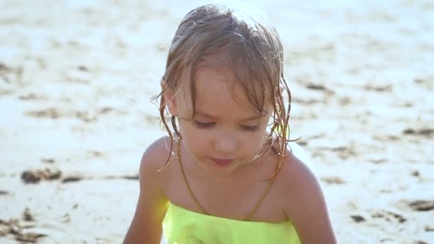 かわいいの金髪の女の子が湖で砂で遊んで — ストック動画