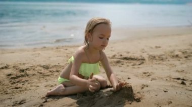 Sevimli küçük kız beyaz kum plaj üzerinde oynama