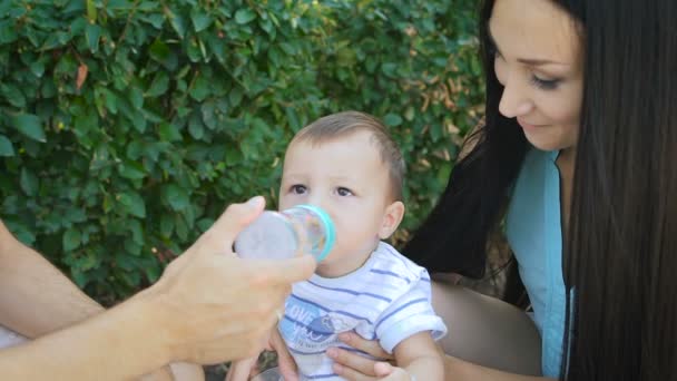 Jonge moeder bedrijf baby terwijl zijn vader zoon zingt. — Stockvideo