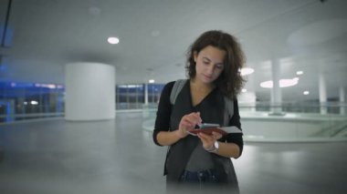 Güzel bir genç kadın yeni telefonunu yolculuk öncesi kontrol ediyor