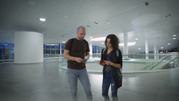 Щаслива молода пара чекає на поїздку в аеропорту — стокове відео