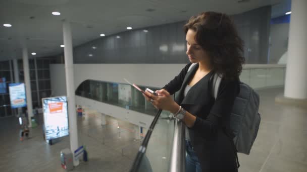 Eine junge schöne Frau plaudert vor dem Flug mit ihrem Freund. — Stockvideo